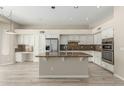 Bright kitchen features white cabinets, stainless steel appliances, and a large granite island at 6528 W Via Montoya Dr, Glendale, AZ 85310