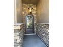 Close-up of the ornate, arched front door with decorative wrought iron and stone trim at 6821 W Donald Dr, Glendale, AZ 85310