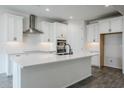 Modern kitchen features white cabinets, quartz countertops, stainless steel appliances, and an island at 7531 W Odeum Ln, Phoenix, AZ 85043