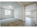 Bright living room with neutral carpet, large windows, and a view into another room at 7531 W Odeum Ln, Phoenix, AZ 85043