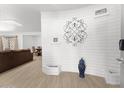 Stylish living room with a white accent wall and tiled floors extending into dining and living areas at 8044 N 10Th Pl, Phoenix, AZ 85020