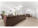 Spacious open-concept living area with wood-look tiled flooring, a ceiling fan and sliding glass doors at 8044 N 10Th Pl, Phoenix, AZ 85020