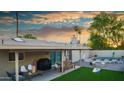 Outdoor living space featuring a covered patio, dining set, and artificial turf, perfect for entertaining at 8338 E Monterosa St, Scottsdale, AZ 85251