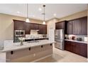 Modern kitchen featuring dark wood cabinets, stainless steel appliances, and a granite-topped island at 10007 E Hillside Dr, Scottsdale, AZ 85255