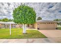 Charming home featuring a well-manicured lawn and mature landscaping under a partially cloudy sky at 10435 W Roundelay Cir, Sun City, AZ 85351