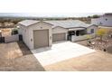 Aerial view showcasing the home's front elevation, three-car garage, driveway, and xeriscaping at 34047 N 10Th St, Phoenix, AZ 85085