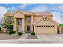 Tan two-story home with well-manicured landscaping, and a spacious two-car garage at 4106 E Lavender Ln, Phoenix, AZ 85044