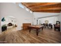 Spacious living room with wood-look floors, vaulted ceilings, and views into the dining room and fireplace area at 5001 E Redfield Rd, Scottsdale, AZ 85254