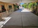 Long covered driveway with a view to the front gate and landscaping providing a shaded parking area at 5120 E Janice Way, Scottsdale, AZ 85254