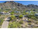 A beautiful aerial view of the home nestled among the desert landscape and mountains at 5412 E Rockridge Rd, Phoenix, AZ 85018