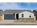 Inviting single-story home with stone accents, low-maintenance landscaping, and attached two-car garage at 8634 W Albeniz Pl, Tolleson, AZ 85353