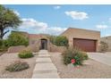 Charming single-story home with desert landscaping, featuring a stucco exterior, and a two-car garage on a sunny day at 11366 E White Feather Ln, Scottsdale, AZ 85262