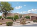 Single-story stucco home with desert landscaping, an arched entrance, and a two-car garage in a residential neighborhood at 11366 E White Feather Ln, Scottsdale, AZ 85262