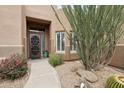 Close-up of a charming home's front entrance with desert landscaping and large decorative succulents at 11366 E White Feather Ln, Scottsdale, AZ 85262