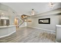 Spacious living room with gray wood floors, staircase, and modern lighting fixture at 16 W Encanto Blvd # 22, Phoenix, AZ 85003