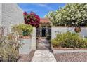 Charming home featuring a tile roof, lush landscaping, and a beautiful black iron gate at 1978 E Carver Rd, Tempe, AZ 85284