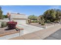 Garage with white door and brick trimmed planters and driveway at 1978 E Carver Rd, Tempe, AZ 85284
