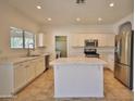 Bright kitchen features white cabinetry, stainless steel appliances, and an island with quartz countertops at 4119 E Tether Trl, Phoenix, AZ 85050