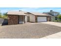 Attractive exterior view, highlighting the home's brick accents, tidy landscaping, and garage at 4631 N 77Th Dr, Phoenix, AZ 85033