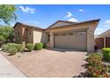 Charming single-story home with stone detailing, a two-car garage, and a neatly paved driveway at 10741 E Palladium Dr, Mesa, AZ 85212