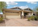 Charming single-story home with a brick paver driveway, well-kept landscaping, and a two-car garage at 13728 W Linanthus Rd, Peoria, AZ 85383