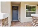 Inviting front entry with brick pavers and stone accents around the porch and a blue front door at 13728 W Linanthus Rd, Peoria, AZ 85383