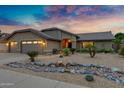 Charming single-Gathering home featuring desert landscaping, three-car garage, and covered front porch at 4338 W Creedance Blvd, Glendale, AZ 85310