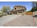 Charming two-story home showcasing a three-car garage and mature trees at 6264 E Omega St, Mesa, AZ 85215
