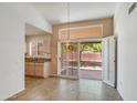 Bright dining area with chandelier lighting and sliding glass doors to backyard and view of adjacent kitchen at 6942 S Championship Dr, Chandler, AZ 85249