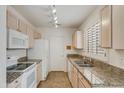 Well-lit kitchen featuring granite countertops, white appliances, and ample cabinet space at 6942 S Championship Dr, Chandler, AZ 85249