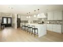 Open concept kitchen with island, stainless steel appliances, pendant lights, and a breakfast bar at 8425 E Welsh Trl, Scottsdale, AZ 85258