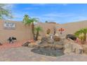 Charming backyard oasis with rock waterfall feature, mature landscaping, and decorative bear statues at 9740 W Rockwood Dr, Peoria, AZ 85382