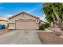 Home exterior featuring a well-kept garage, driveway, and landscaped front yard with a neatly trimmed tree at 10407 W Reade Ave, Glendale, AZ 85307