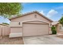 A tidy home exterior showcasing a garage, concrete driveway, and low-maintenance desert landscaping at 10407 W Reade Ave, Glendale, AZ 85307