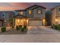 Charming two-story home featuring a well-manicured lawn, covered entryway, and a two car garage at sunset at 10986 W Polk St, Avondale, AZ 85323