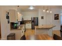 Well-lit kitchen with white cabinets, granite countertops, stainless steel appliances, and wood floors at 11265 E Contessa St, Mesa, AZ 85207