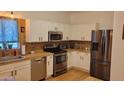 Updated kitchen featuring white cabinets, granite countertops, and stainless steel appliances at 11265 E Contessa St, Mesa, AZ 85207