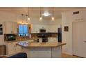 Bright kitchen with white cabinets, granite countertops, stainless steel appliances, and stylish pendant lighting at 11265 E Contessa St, Mesa, AZ 85207