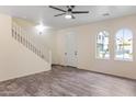 Spacious living room featuring tile flooring, a staircase, and arched windows at 11454 W St John Rd, Surprise, AZ 85378