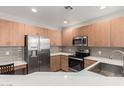 Well-lit kitchen boasts modern stainless steel appliances and wooden cabinets for a functional space at 11640 N Tatum Blvd # 1031, Phoenix, AZ 85028