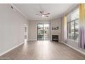 Bright living room featuring a fireplace, ceiling fan, and a sliding door for balcony access at 11640 N Tatum Blvd # 1031, Phoenix, AZ 85028