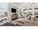 Bright living room featuring dark floors, many windows, and a sectional couch at 12335 W Rosewood Ln, Peoria, AZ 85383