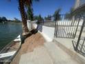 Waterfront property featuring a dock, grassy area, retaining wall, and fenced yard at 1414 N Palmsprings Dr, Gilbert, AZ 85234