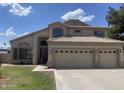 Exterior of the home with a three-car garage and landscaped front yard at 1414 N Palmsprings Dr, Gilbert, AZ 85234