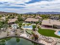This aerial view shows a home with a backyard featuring a pool, putting green, and lake at 15645 S 17Th St, Phoenix, AZ 85048