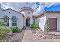 Inviting front entrance with arched doorway and manicured landscaping, leading to a beautiful home at 16445 W Berkeley Rd, Goodyear, AZ 85395