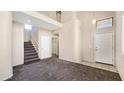 A welcoming two-story entryway featuring carpeted stairs and neutral walls, offering a view into the home's layout at 1909 N 106Th Ave, Avondale, AZ 85392