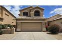 Charming two-story home featuring a two-car garage and a well-maintained desert landscape under a sunny sky at 1909 N 106Th Ave, Avondale, AZ 85392