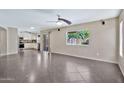 Bright living room with large windows overlooking the backyard and an open layout connected to the kitchen at 2418 W White Feather Ln, Phoenix, AZ 85085
