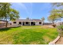 Expansive backyard features a lush lawn, mature trees, and a covered patio area perfect for outdoor entertaining at 28061 N Holly Rd, San Tan Valley, AZ 85143